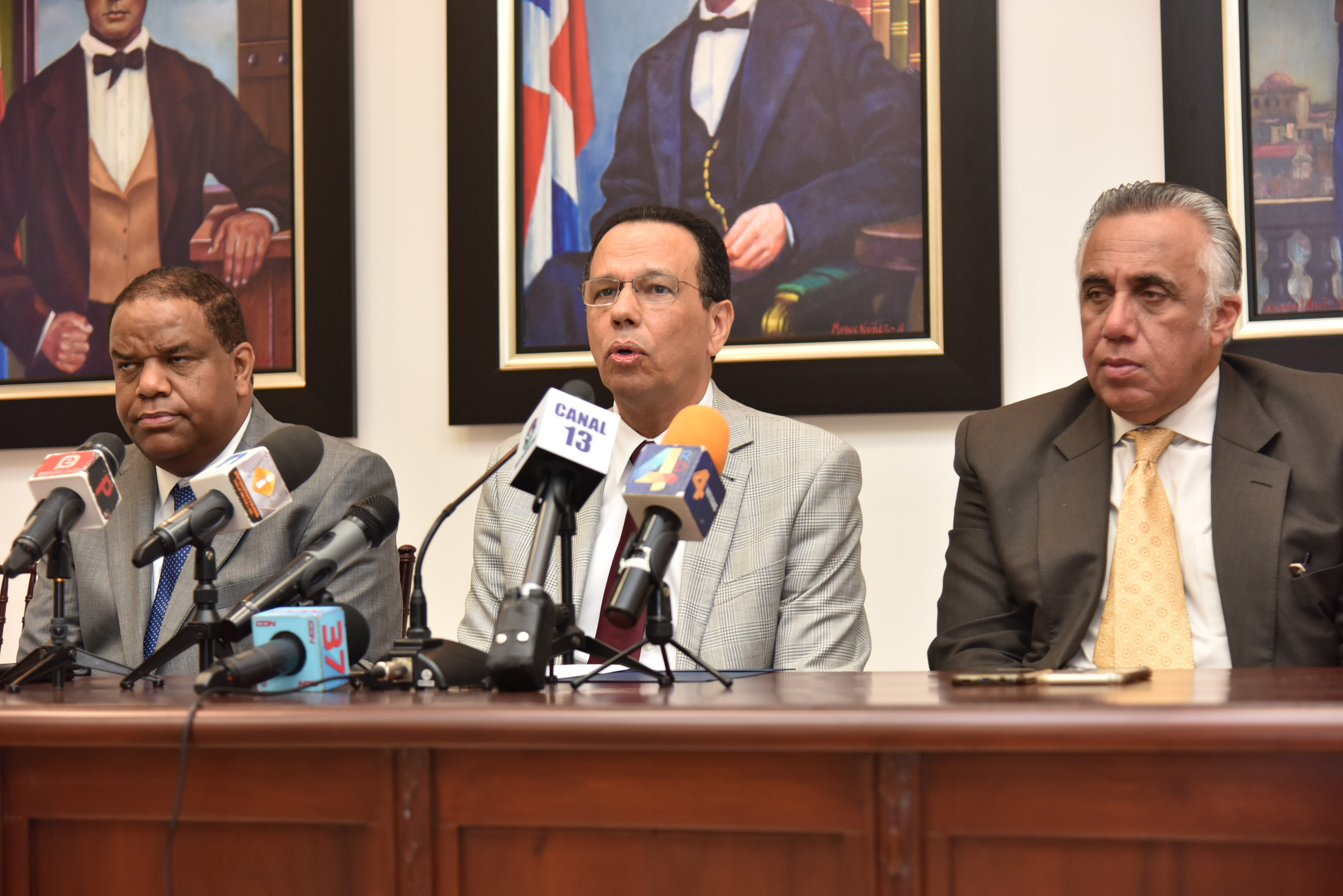  imagen Ministro de educación sentado en mesa junto a Danilo Díaz y Mejía Oviedo durante rueda de prensa. 