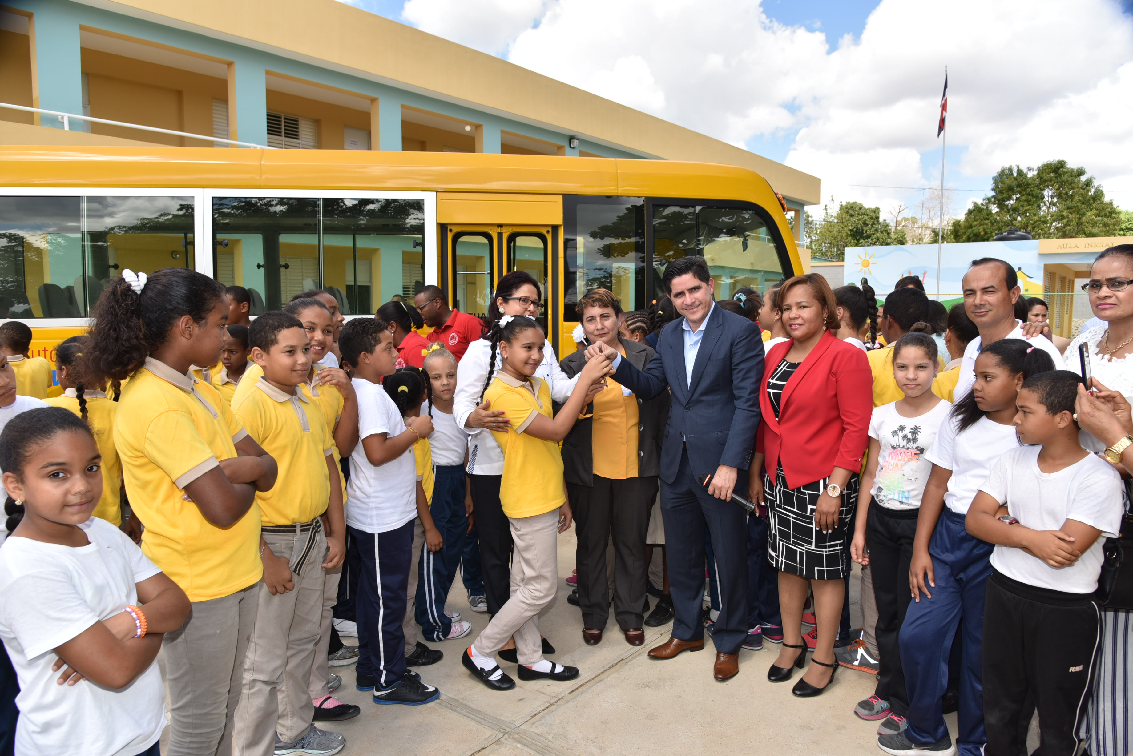  imagen Director Administrativo MINERD, Jorge Luis Moronta de pie entregando llave de nuevo autobús escolar a representabtes de la comunidad educativa de Partido Dajabón  