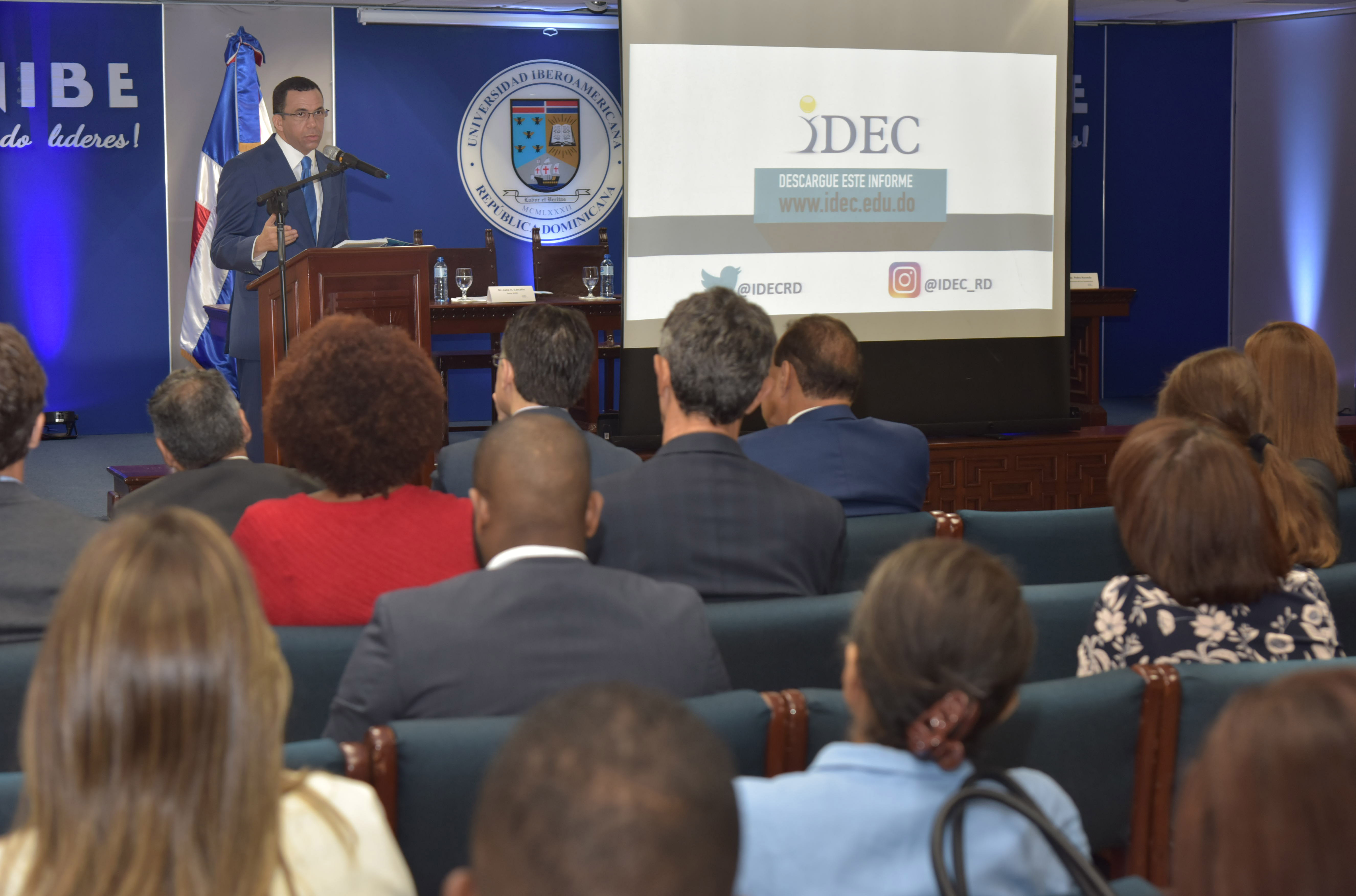  imagen Ministro Andrés Navarro desde podium de pie se dirige a personas en presentación de resultados de informe y monitoreo del IDEC  