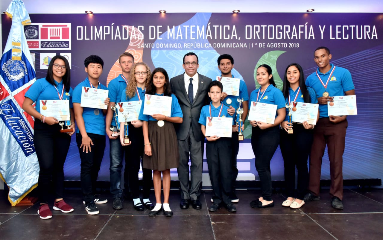  imagen Ministro Andrés Navarro de pie junto a estudiantes galardonados de las olimpíadas de Matemática, Ortografía y Lectura  