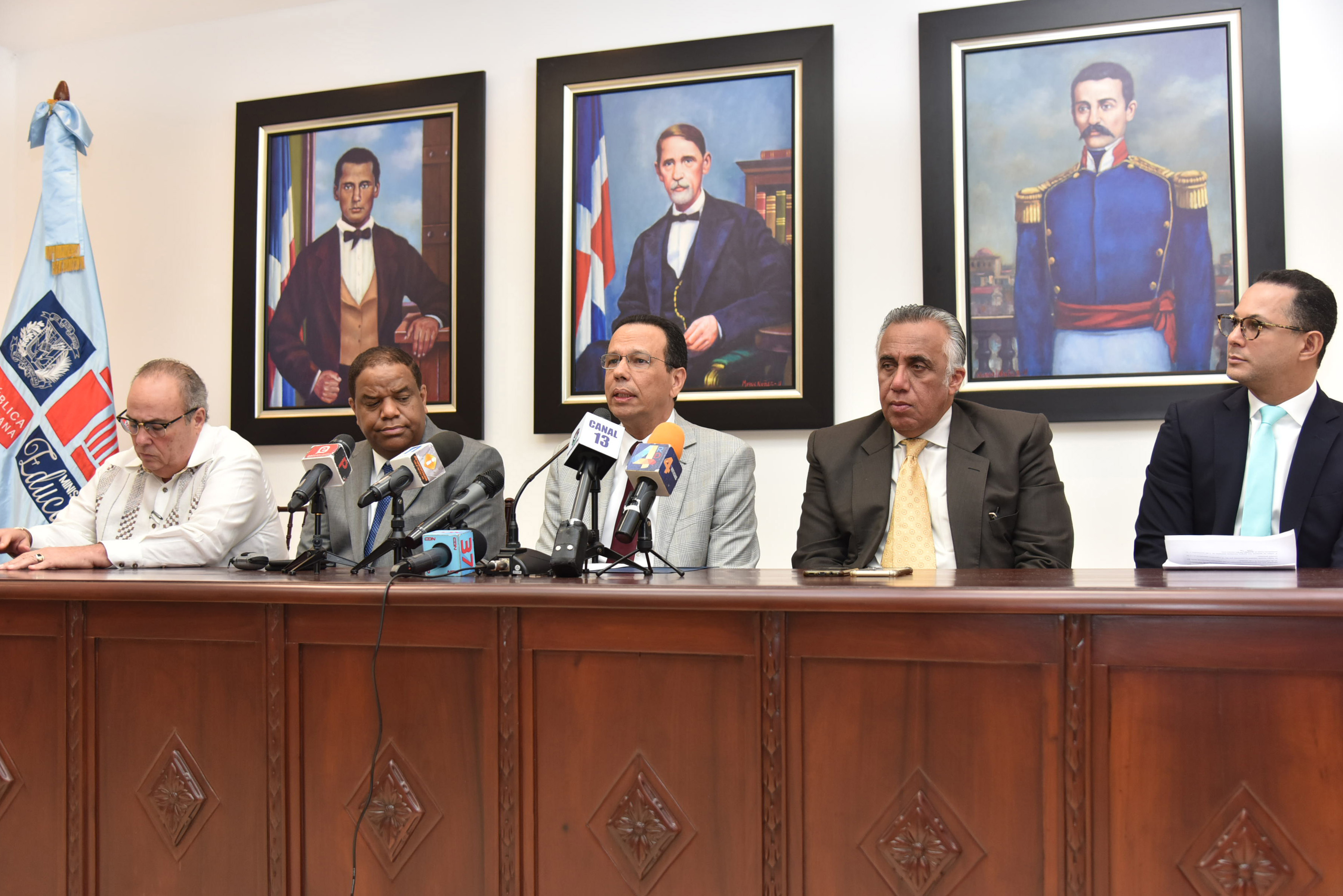  imagen Ministro de educación sentado en mesa junto a Danilo Díaz y Mejía Oviedo durante rueda de prensa. 