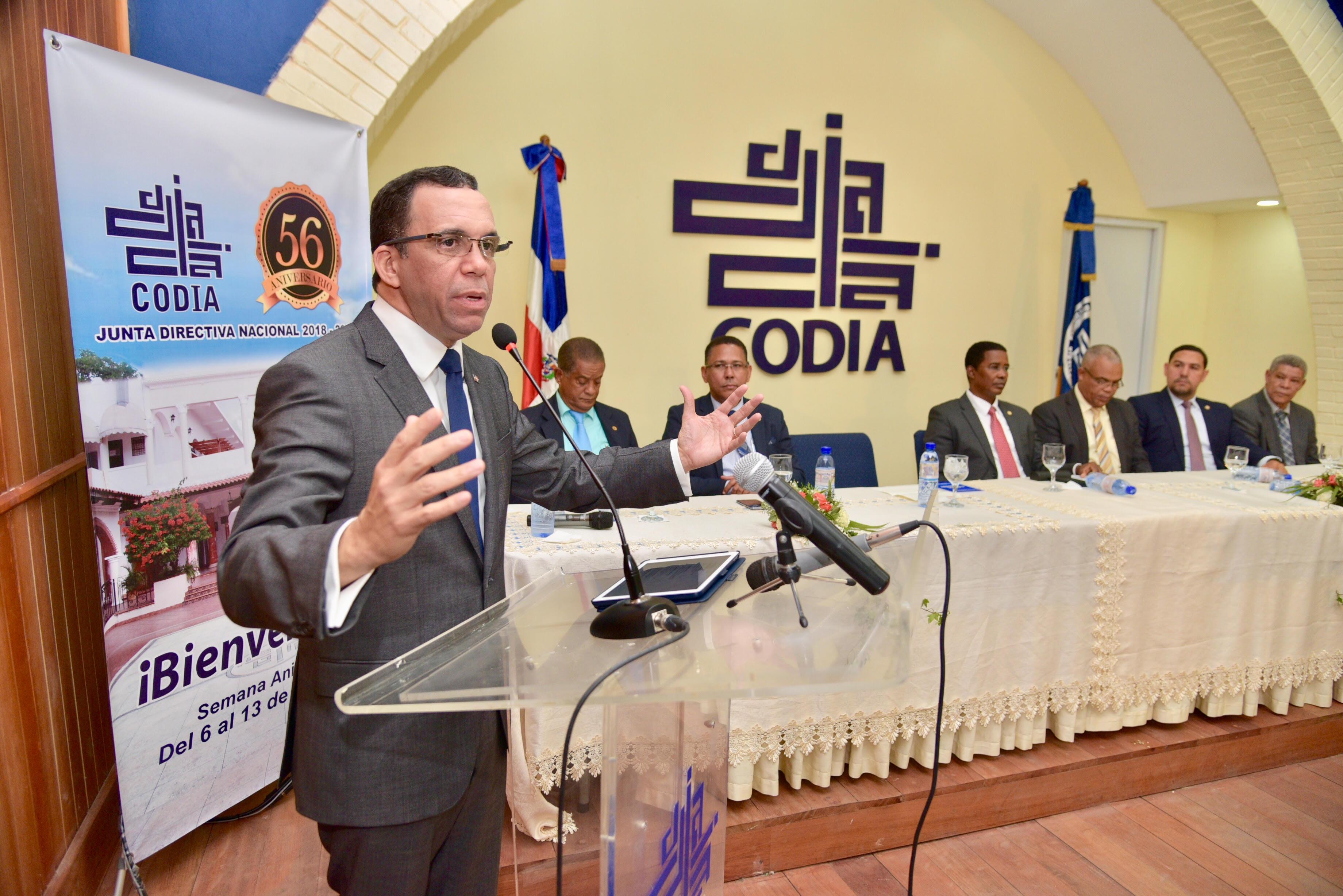  imagen Ministro de Educación Andrés Navarro de pie en podium dirigiendo conferencia magistral en el Colegio Dominicano de Ingenieros, Arquitectos y Agrimensores.  
