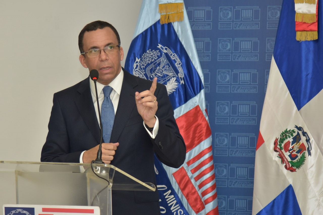  imagen Ministro Andrés Navarro de pie en podium se dirige a los medios  