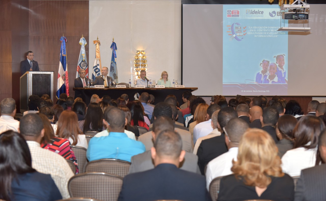  imagen Ministro Andrés Navarro de pie en podium hablando sobre retos de la educación frete a cientos de autoridades del sistema educativo 