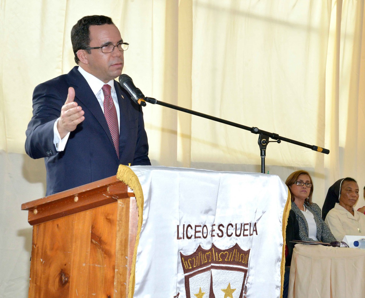  imagen Ministro Andrés Navarro en podium llama a reinicio de clases. 