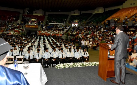  imagen Ministro Andrés Navarro en podium se dirige a graduados en acto ceremonial de graduación. 