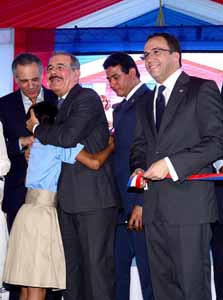  imagen Presidente Danilo Medina sonriente abraza una estudiante. A su lado el Ministro Andrés Navarro, entre otras personalidades. 
