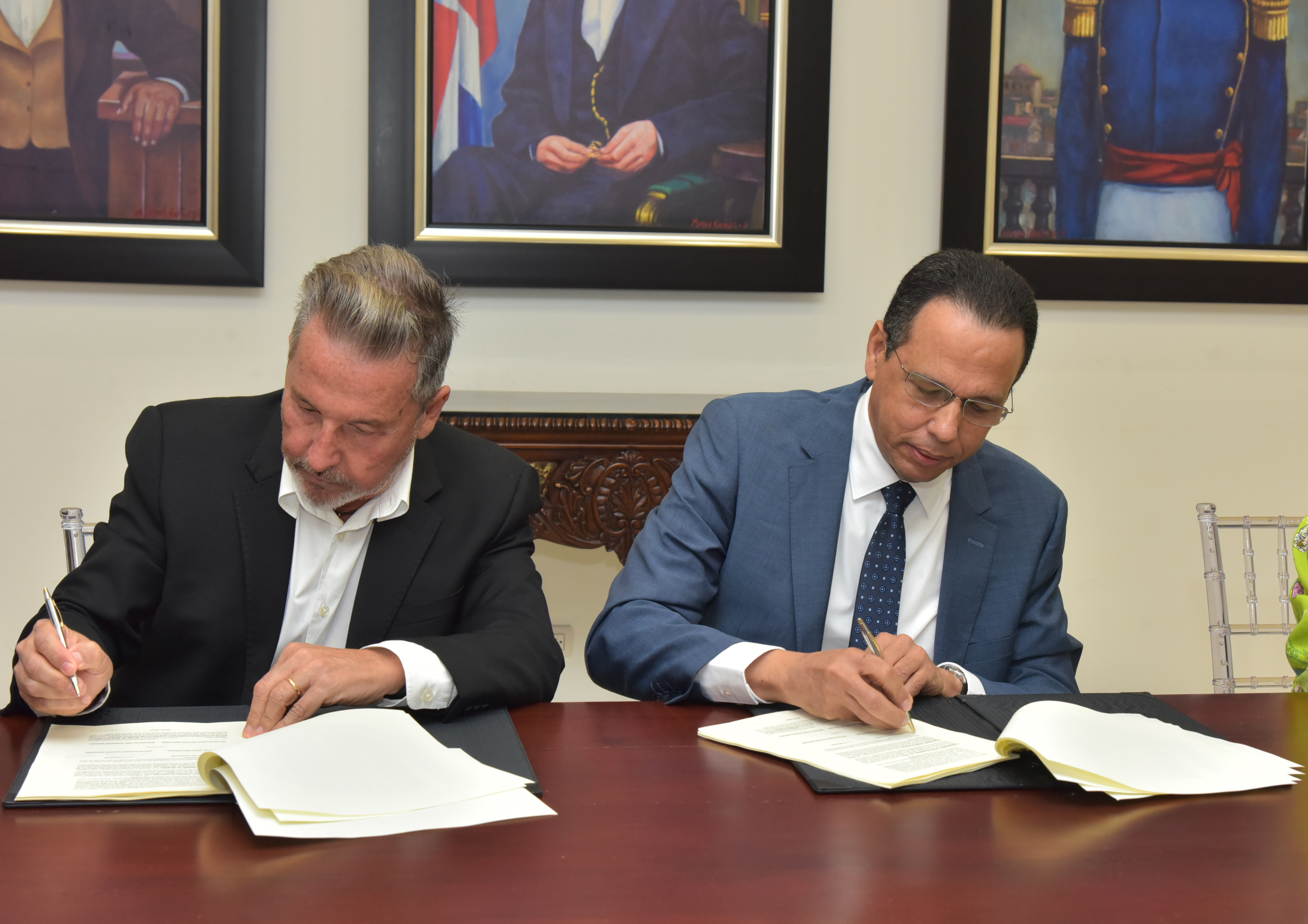  imagen Ministo Pe&ntilde;a Mirabal y el cantante Ricardo Montaner mientras firman acuerdo con fundacion del artista. 