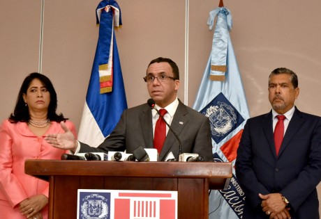  imagen Ministro Andrés Navarro en podium se dirige a los medios en rueda de prensa. A la derecha del Ministro la Sra. Miguelina Santana, a la Izquierda el Sr. Milton Torres. 