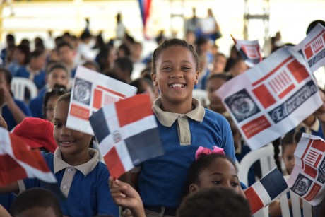  imagen Estudiante feliz vistiendo uniforme escolar, sostiene bandera dominicana. 